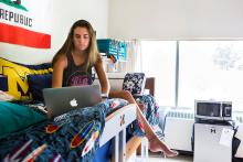 Student sitting on bed