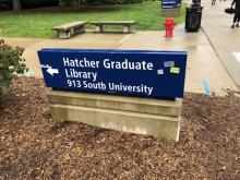 Building sign for Hatcher Library with the UGLI sign in the background.