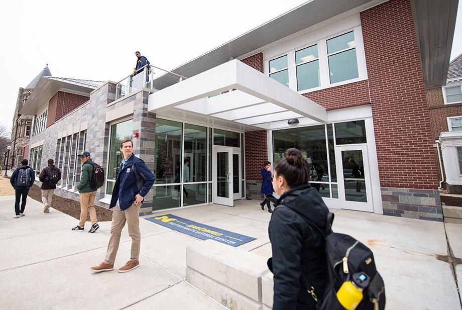 Image of Trotter Multicultural Center with students on the sidewalk and balcony.